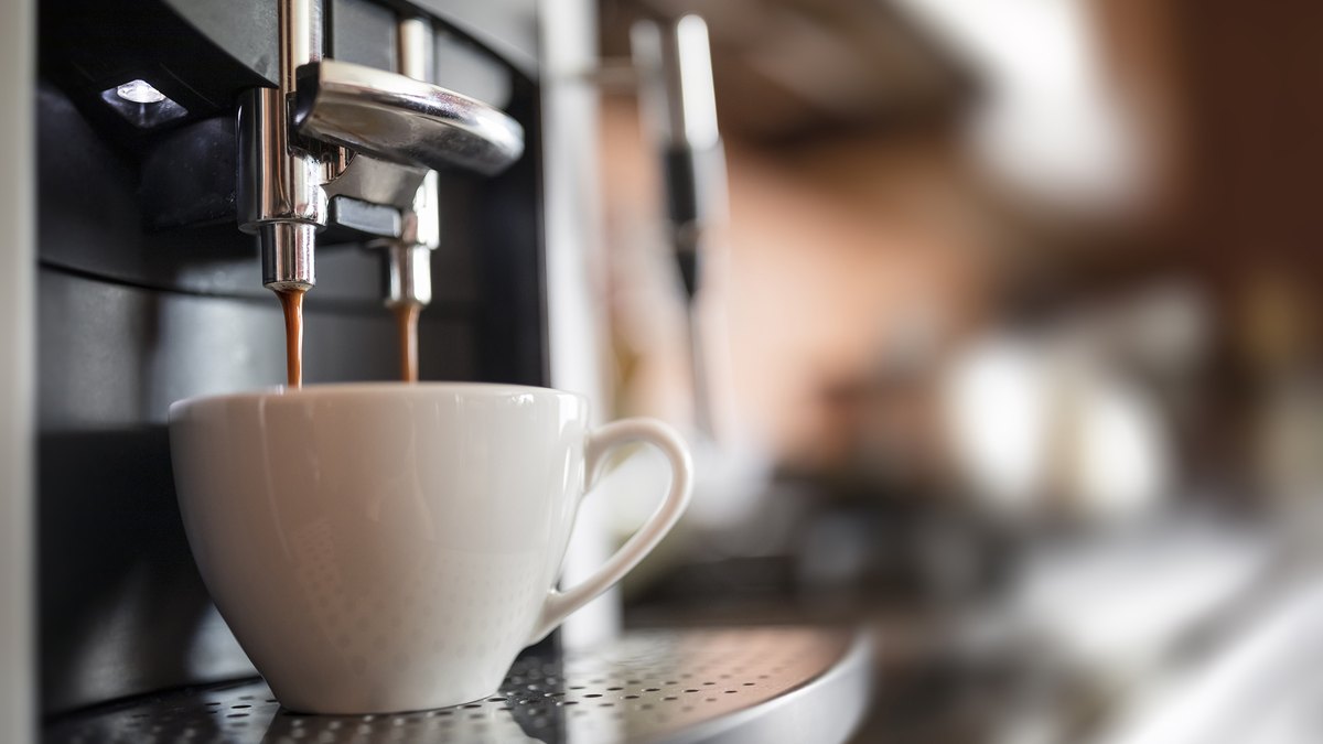 Espresso being poured into a white coffee cup